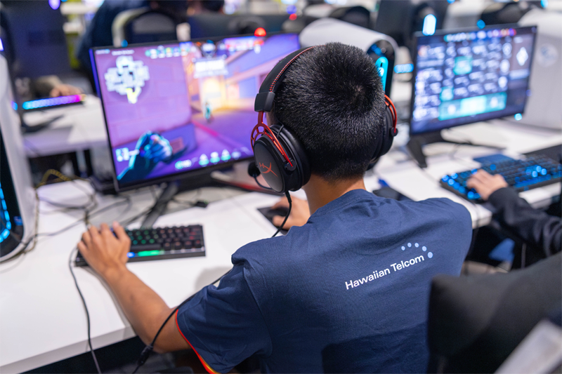 A kid wearing a Hawaiian Telcom branded esports jersey playing Valorant