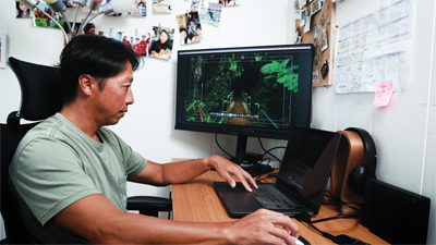 Man at his desk on the computer editing a video