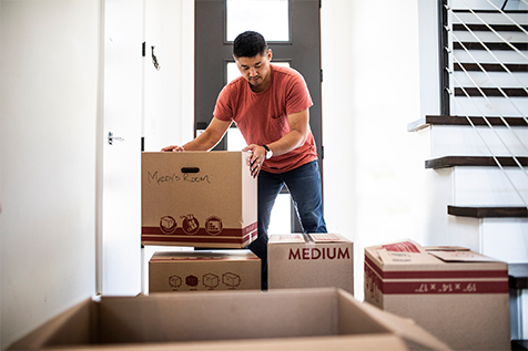 A man moving boxes in his new house